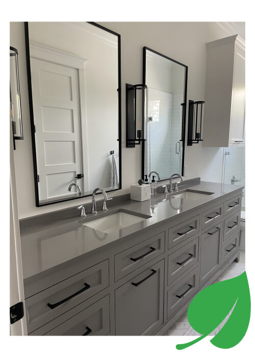 A mirror on the wall, two sink and drawers with gray theme